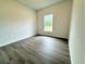 Bedroom with neutral-toned walls, wood-look flooring, and a bright window, creating a calming atmosphere at 1304 Hillsborough Ct, Kissimmee, FL 34759