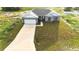 Charming gray home features an attached garage, and seeded lawn, and freshly painted white trim at 1304 Hillsborough Ct, Kissimmee, FL 34759