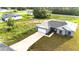 Charming gray home boasts a long driveway, attached garage, and a freshly seeded lawn at 1304 Hillsborough Ct, Kissimmee, FL 34759
