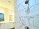 Bathroom featuring a shower showcasing marble-style tile and modern fixtures, complementing the stylish vanity at 1304 Hillsborough Ct, Kissimmee, FL 34759
