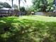 Spacious backyard features a playset, grassy area, and a wooden fence at 1361 Sterling Oaks Dr, Casselberry, FL 32707