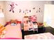 Bright bedroom features wood floors, a pink bed, a play kitchen, and cartoon wall decor at 1361 Sterling Oaks Dr, Casselberry, FL 32707