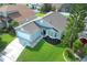 Aerial view of a well-maintained single-story home with lush landscaping, a two-car garage, and a spacious driveway at 14130 Leicester Ln, Orlando, FL 32828