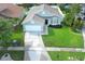 Overhead shot of attractive home with manicured lawn, garden beds, two car garage and concrete driveway at 14130 Leicester Ln, Orlando, FL 32828