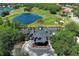 Stunning aerial view of a clubhouse with a golf course, lake, and lush landscaping at 14130 Leicester Ln, Orlando, FL 32828