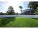Large grassy backyard with a white fence and a screened pool in the distance at 14130 Leicester Ln, Orlando, FL 32828