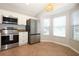 Bright kitchen featuring stainless steel appliances, white cabinets, and a breakfast nook at 14130 Leicester Ln, Orlando, FL 32828