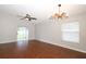 Open-concept living room with hardwood floors, natural light from a large window, and sliding door access to the backyard at 14130 Leicester Ln, Orlando, FL 32828