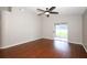 Spacious living room featuring hardwood floors, a ceiling fan, and sliding doors leading to the screened patio at 14130 Leicester Ln, Orlando, FL 32828