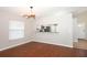 Open living room with hardwood floors, modern lighting, and breakfast bar to the kitchen at 14130 Leicester Ln, Orlando, FL 32828
