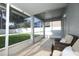 Light-filled screened patio with tile floors and wicker furniture offering a serene view of the landscaped backyard at 14130 Leicester Ln, Orlando, FL 32828