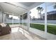 Inviting screened-in lanai showcasing tiled flooring and wicker seating that overlooks the lush green backyard at 14130 Leicester Ln, Orlando, FL 32828