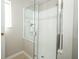 Shower with glass enclosure showcasing white tiles with a decorative accent stripe at 14130 Leicester Ln, Orlando, FL 32828