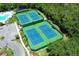 Aerial view of four well-maintained tennis courts surrounded by lush greenery at 14130 Leicester Ln, Orlando, FL 32828