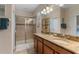 Bathroom showcasing granite counters, dual sinks, and a glass-enclosed shower in a modern design at 1442 Moon Valley Dr, Davenport, FL 33896