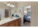 Bright bathroom with a spacious vanity, decorative mirror and convenient access to the bedroom and shower at 1442 Moon Valley Dr, Davenport, FL 33896