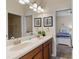 Bathroom highlighting double sinks with granite counters and an adjacent room featuring a bed and a window at 1442 Moon Valley Dr, Davenport, FL 33896
