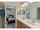 Bathroom showcasing double sinks with a modern lighting fixture, connecting to another room through a doorway at 1442 Moon Valley Dr, Davenport, FL 33896