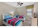Twin bedroom featuring bright bedding, neutral tones, and a window, creating a cozy shared space at 1442 Moon Valley Dr, Davenport, FL 33896