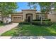 Charming home with a stone facade, manicured lawn, and inviting entrance at 1442 Moon Valley Dr, Davenport, FL 33896