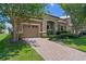 Lovely home featuring a brick driveway, two-car garage, and verdant landscaping at 1442 Moon Valley Dr, Davenport, FL 33896