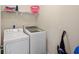 Functional laundry room with modern washer and dryer, plus overhead storage for supplies at 1442 Moon Valley Dr, Davenport, FL 33896