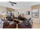 Cozy living room with comfortable leather sofas, tile flooring, and a ceiling fan at 1442 Moon Valley Dr, Davenport, FL 33896