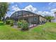 This is a screened-in pool area, surrounded by lush landscaping, offering a private outdoor oasis at 1442 Moon Valley Dr, Davenport, FL 33896