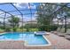 The screened-in pool area has a shimmering pool, spa, and lounge chairs for relaxation and enjoyment at 1442 Moon Valley Dr, Davenport, FL 33896