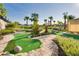 Outdoor putting green area with lush landscaping and palm trees at 1442 Moon Valley Dr, Davenport, FL 33896