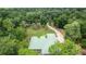 Stunning aerial view of a house with a lush green lawn surrounded by mature trees and a curving driveway at 1908 S Farm Rd, Deland, FL 32720