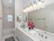 Well-lit bathroom with dual sinks, a wide mirror, and a bathtub at 1908 S Farm Rd, Deland, FL 32720