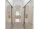 Bright bathroom featuring double vanities, a soaking tub beneath arched windows, and pristine tiled floors at 1908 S Farm Rd, Deland, FL 32720
