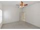 Clean bedroom with a window, ceiling fan, neutral carpet, and an open doorway to another room at 1908 S Farm Rd, Deland, FL 32720