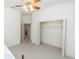 Bright bedroom with open closet, neutral carpet, a ceiling fan, and views into the en suite at 1908 S Farm Rd, Deland, FL 32720