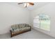 Bedroom with a comfortable floral patterned sofa by a bright arched window and plush carpeting at 1908 S Farm Rd, Deland, FL 32720