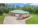Aerial view of a brick home featuring a metal roof, a garage and a curved sidewalk at 1908 S Farm Rd, Deland, FL 32720