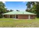 Beautiful single-story home with a metal roof, brick exterior and landscaped backyard at 1908 S Farm Rd, Deland, FL 32720