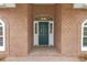 Close up of a front door with white sidelights and transom window, surrounded by a brick facade at 1908 S Farm Rd, Deland, FL 32720