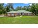 Charming one-story brick home with a green roof, arched windows, and a well-manicured lawn at 1908 S Farm Rd, Deland, FL 32720