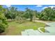 Aerial view of landscaped front yard featuring mature trees, driveway and sidewalk at 1908 S Farm Rd, Deland, FL 32720