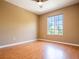 Bright bedroom with a ceiling fan, a window view of greenery, and laminate wood floors at 2006 Stone Abbey Blvd, Orlando, FL 32828