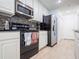 Modern kitchen featuring stainless steel appliances, black backsplash, and white cabinetry at 2006 Stone Abbey Blvd, Orlando, FL 32828