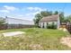 Backyard featuring a grassy area, a concrete slab, and a wooden fence at 25 E Pinecrest Ave, Eustis, FL 32726