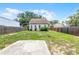 Backyard featuring a grassy area, a concrete slab, and a wooden fence at 25 E Pinecrest Ave, Eustis, FL 32726