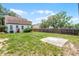 Backyard featuring a grassy area, a concrete slab, and a wooden fence at 25 E Pinecrest Ave, Eustis, FL 32726
