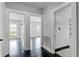 Bright hallway with wood floors offers entrances to rooms with dark floors and white trim at 25 E Pinecrest Ave, Eustis, FL 32726