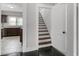 Hallway and staircase featuring freshly painted white walls, access to the kitchen and wood-trimmed steps at 25 E Pinecrest Ave, Eustis, FL 32726