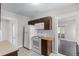 Kitchen with white appliances, light tile flooring, with a view to the living room through an open doorway at 25 E Pinecrest Ave, Eustis, FL 32726