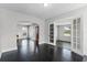 Bright living room with dark wood floors, white walls, and glass-paneled french doors to another room at 25 E Pinecrest Ave, Eustis, FL 32726